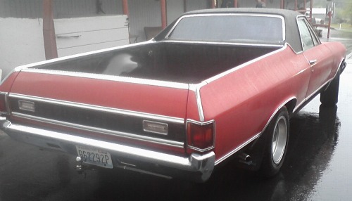 Ford El Camino with spray paint repair and black racing stripes painted on it